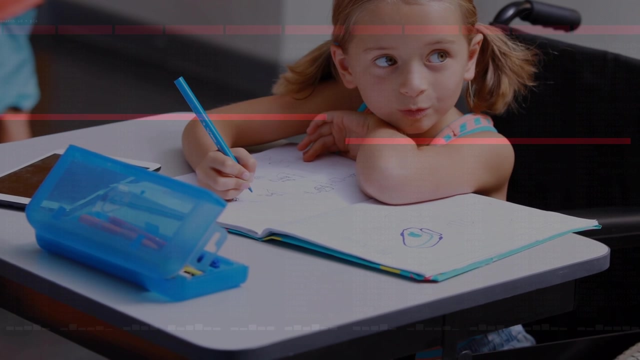 Young Girl Sitting in Wheelchair Drawing in a Notebook