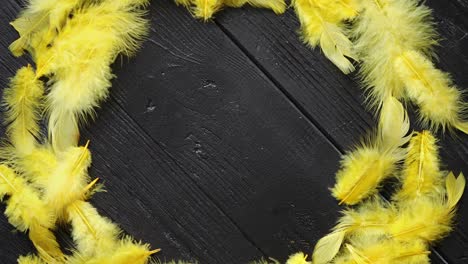 Colorful-decorative-Easter-feather-wreath-on-black-wooden-table-background