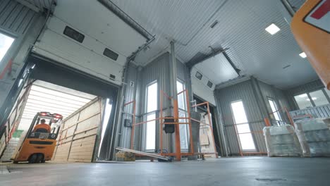 forklift driver transports packaged water bottles in warehouse