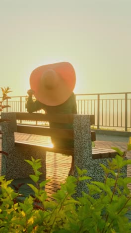 woman sitting on bench at sunrise