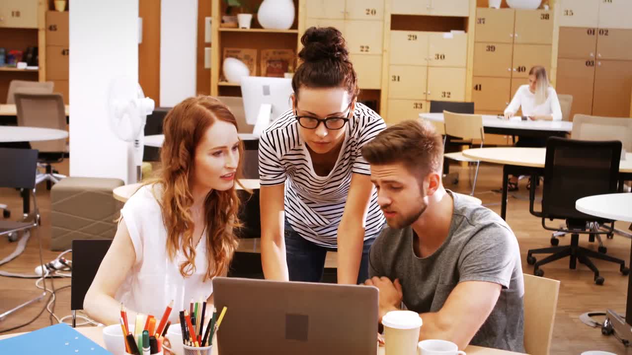 ejecutivos de negocios masculinos y femeninos discutiendo sobre computadora portátil en su escritorio