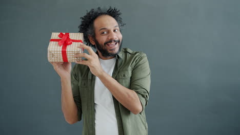 man excitedly holding a gift