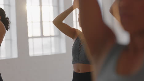 beautiful caucasian yoga woman practicing prayer pose meditation with group of multiracial women enjoying healthy lifestyle exercising in fitness studio at sunrise