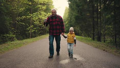 happy-little-boy-and-his-grandfather-are-strolling-in-morning-and-walking-to-fishing-in-weekend