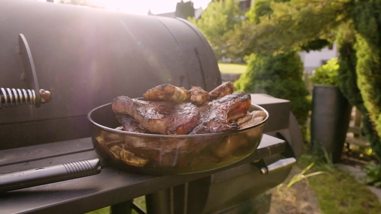 Barbecue con carne in un cestino, perfetto per video e annunci di cibo, con un'atmosfera estiva.