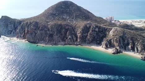 barcos de motor que pasan por las aguas azules en la playa de cabo san lucas marina