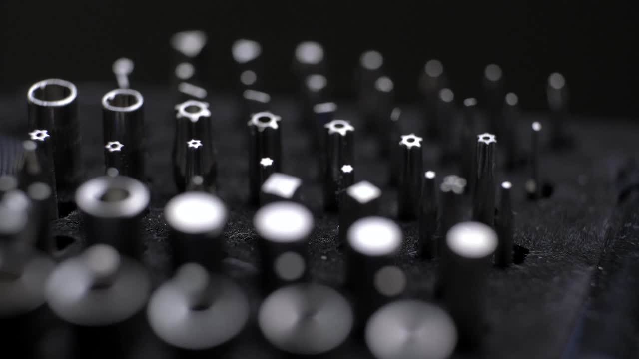 shallow depth of field across torx screws rotating on foam display on black background