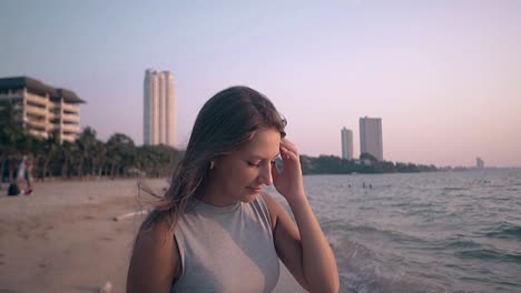 chica atractiva con ropa casual posa en la playa en cámara lenta