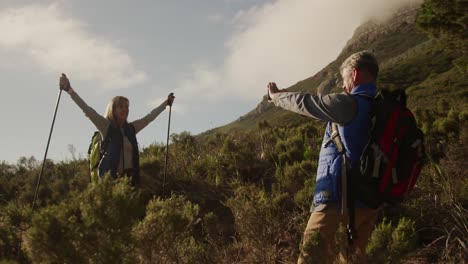 active senior couple taking picture in forest