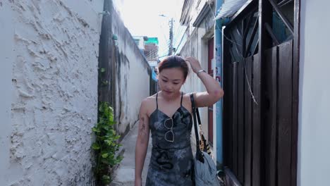 woman walking through a narrow alley in thailand