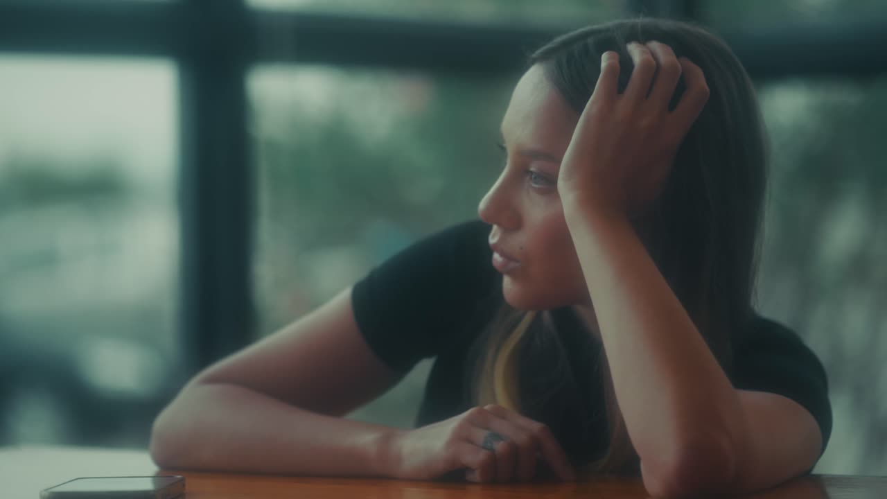 Young Woman Sitting Thoughtfully by a Window