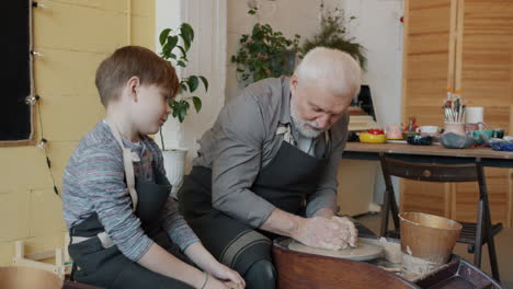 grandfather and grandson learning pottery together