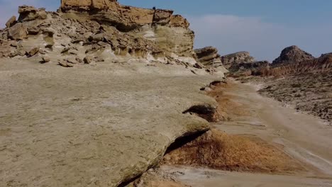 yardang landform in coastal beach dry mud rocky mountain erosion abrasion cloudy blue sky in background wonderful landscape of attraction adventure hiking in iran qatar border harbor unique culture