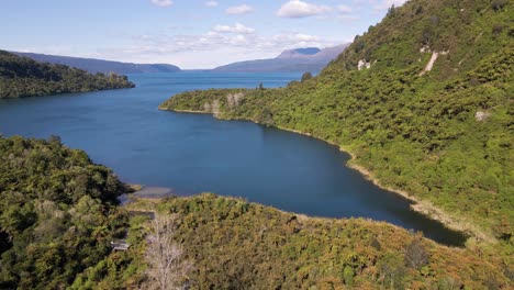 Aerial-view-approaching-Lake-Tarawera-from-high-above-its-lush,-pristine-shore