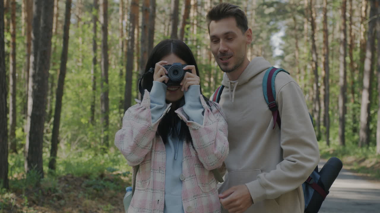 Couple taking photos in a forest