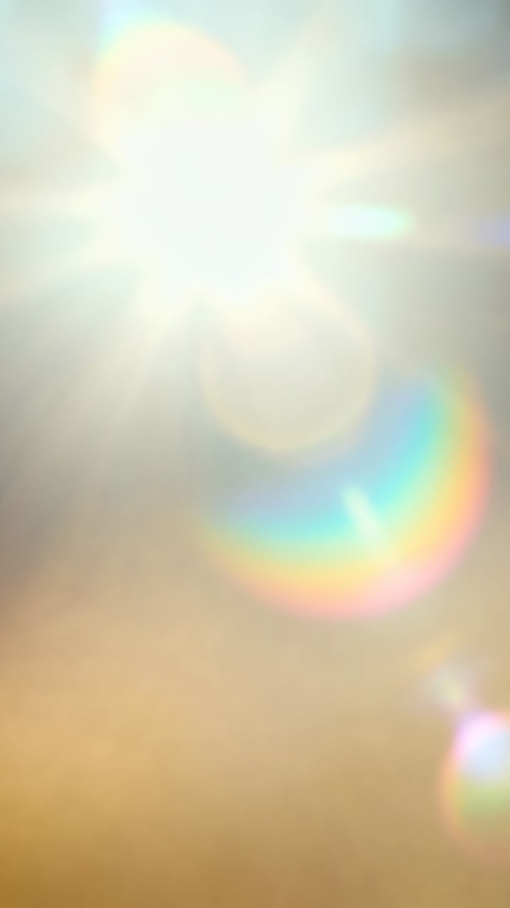 Vídeo vertical: Sol brilhante criando arco-íris crescente com brilho estelar, reflexo enquanto exposição muda no céu.