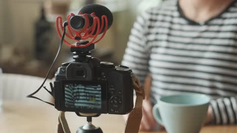 female sitting in front of camera and recording video inside apartment