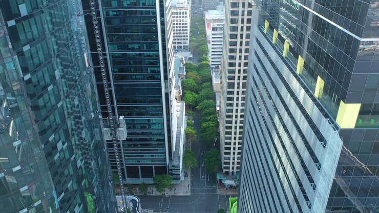 Ripresa aerea con panoramica verso il basso di un grattacielo di Brisbane in costruzione con un ascensore esterno in discesa.