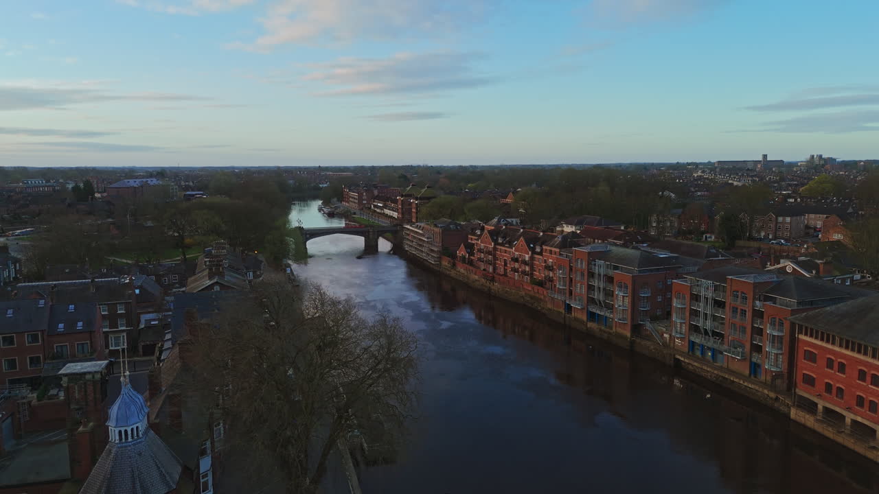 Aerial View of a City River with Historic Buildings and a Bridge at Dusk