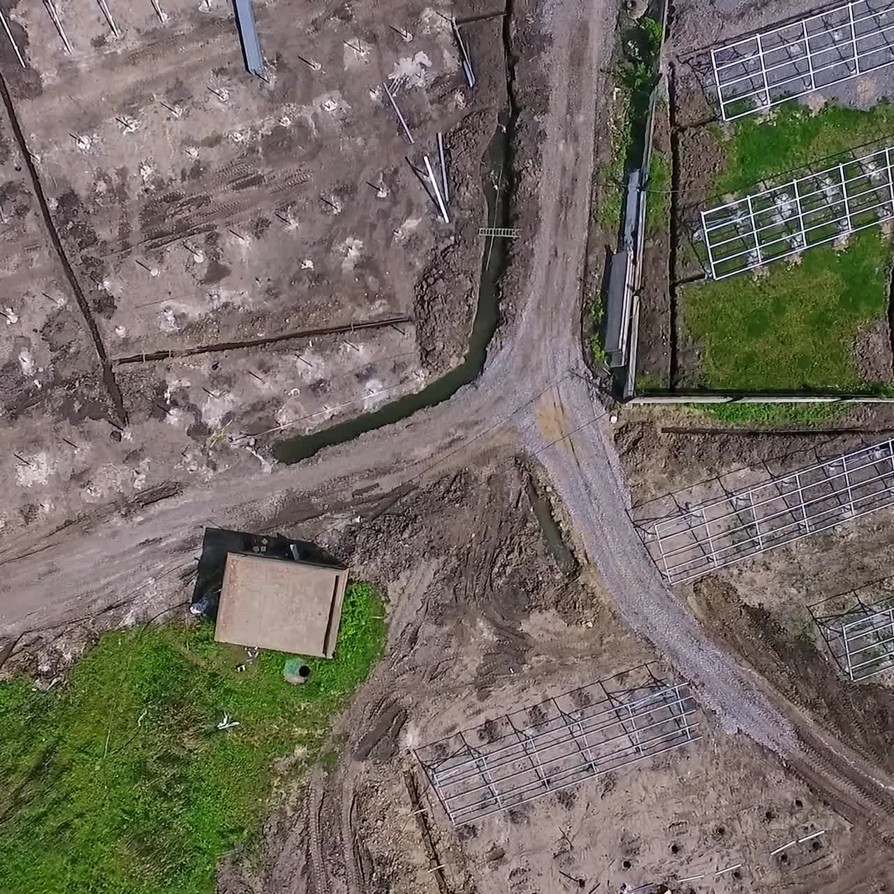 Descending on the plowed land covered with gravel and sand for installing solar panels. Construction site of the future green photovoltaic station