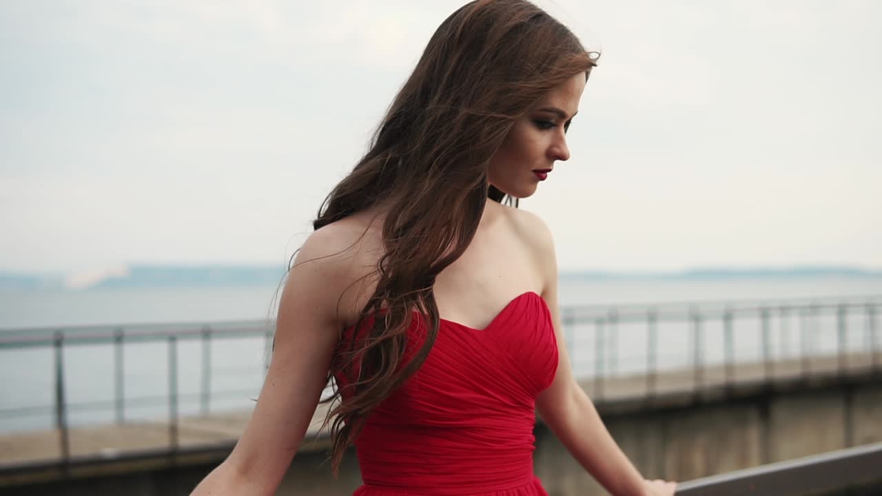 Woman in red dress by the lake