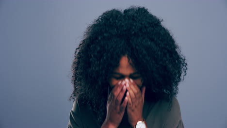 a young woman crying against a grey background