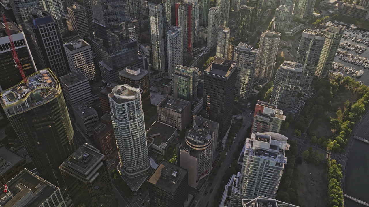 Vancouver BC Canada Aerial v52 bird's eye view drone flyover Coal harbour capturing downtown cityscape with the afternoon sunlight shining on the skyscrapers - Shot with Mavic 3 Pro Cine - July 2023