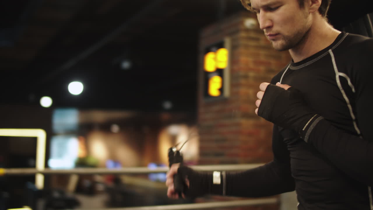 스포츠 클럽에서 몸을 따뜻하게 하는 건강한 남자. 체육관에서 스 ⁇  로프를 사용하는 남성 권투 선수