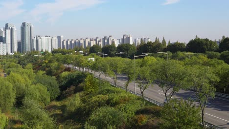 View-on-Seoul-highway,-green-trees-of-the-park-and-Seoul-city-buildings