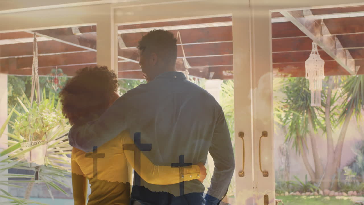animación de puntos de luz sobre una feliz pareja diversa abrazándose en casa
