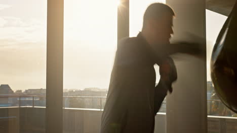 Man,-boxer-and-punching-boxing-bag-in-sunset