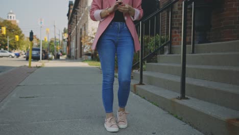 a lovely fit young female model standing with her toned legs crossed - tilt-down slow motion