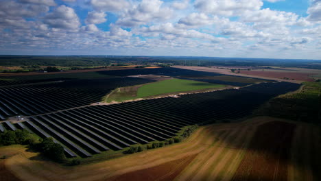 Drohnenaufnahme-Eines-Modernen-Landwirtschaftsgebiets-Mit-Gewächshaus--Und-Windmühlentechnologie