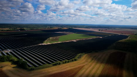 toma de drones de un área agrícola moderna con tecnología de invernaderos y molinos de viento