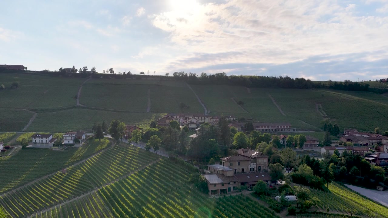 Une prise de vue par drone révèle des vignes ensoleillées et une villa rustique à travers le paysage italien.