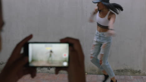 dancing woman happy freestyle dancer friend using smartphone taking video enjoying sharing hip hop dance on social media in grungy urban warehouse