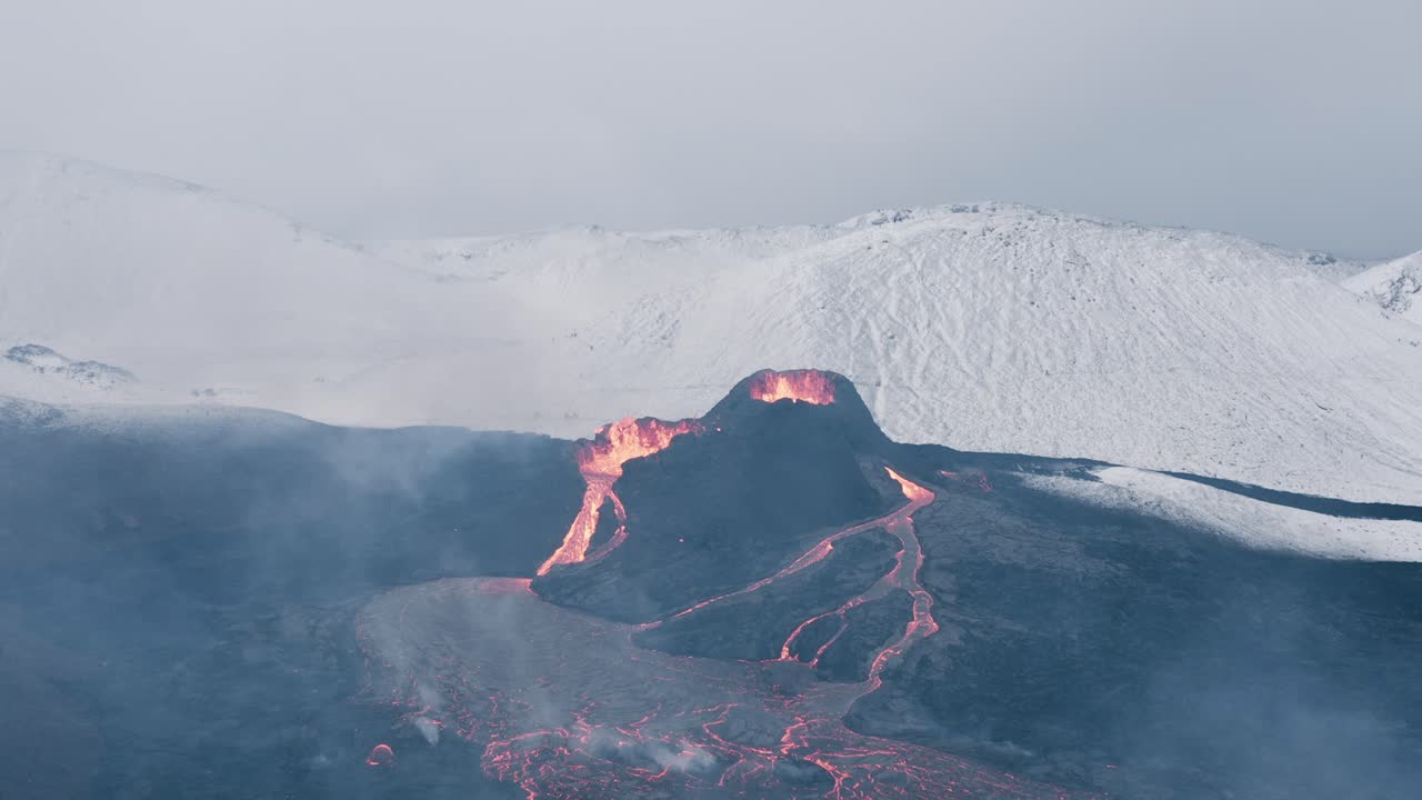 눈 덮인 언덕이 있는 아이슬란드의 겨울 풍경에 활화산 겔딩가달고스 화산