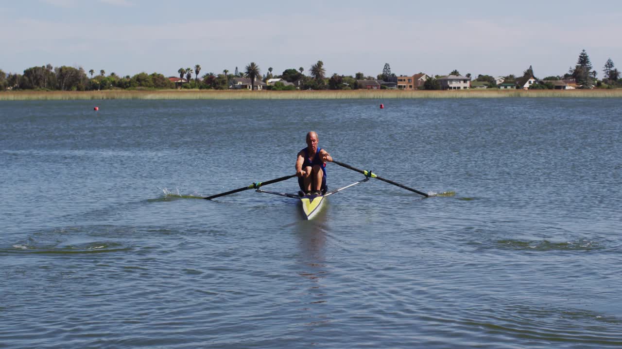 hombre caucásico mayor remando un barco en un río