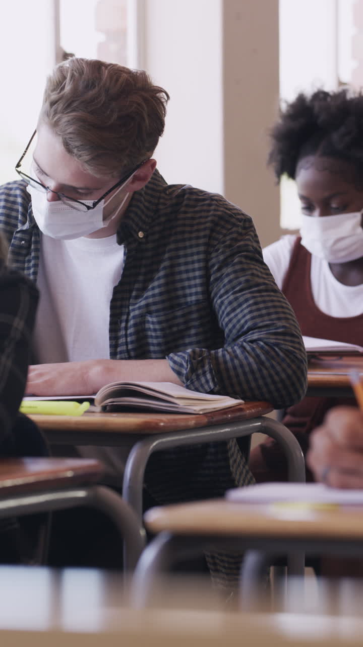 Fokuserede studerende med masker studerer i et klasseværelse