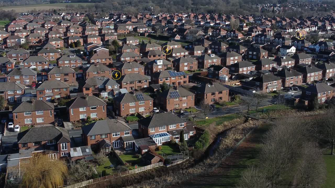 múltiples íconos de energía parpadeando sobre el concepto de propiedad de vecindario británico residencial de vista aérea