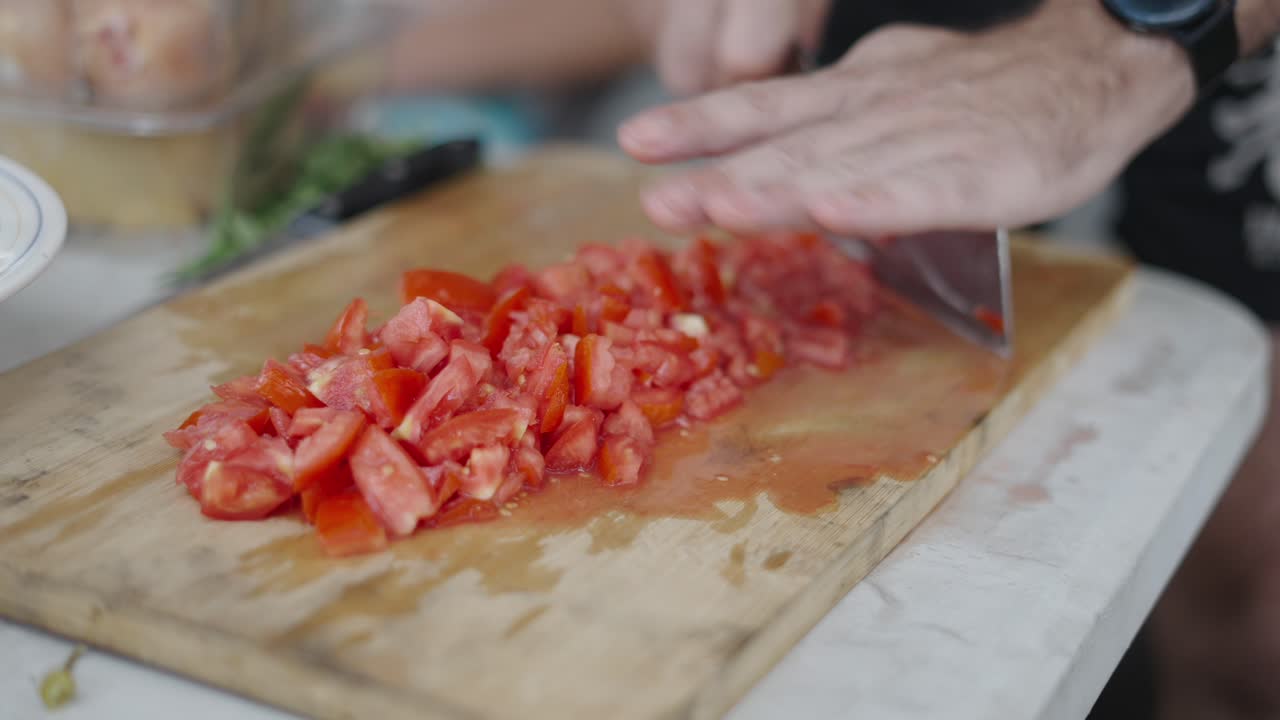 Close-up of Hands Chopping Tomatoes on a Cutting Board
