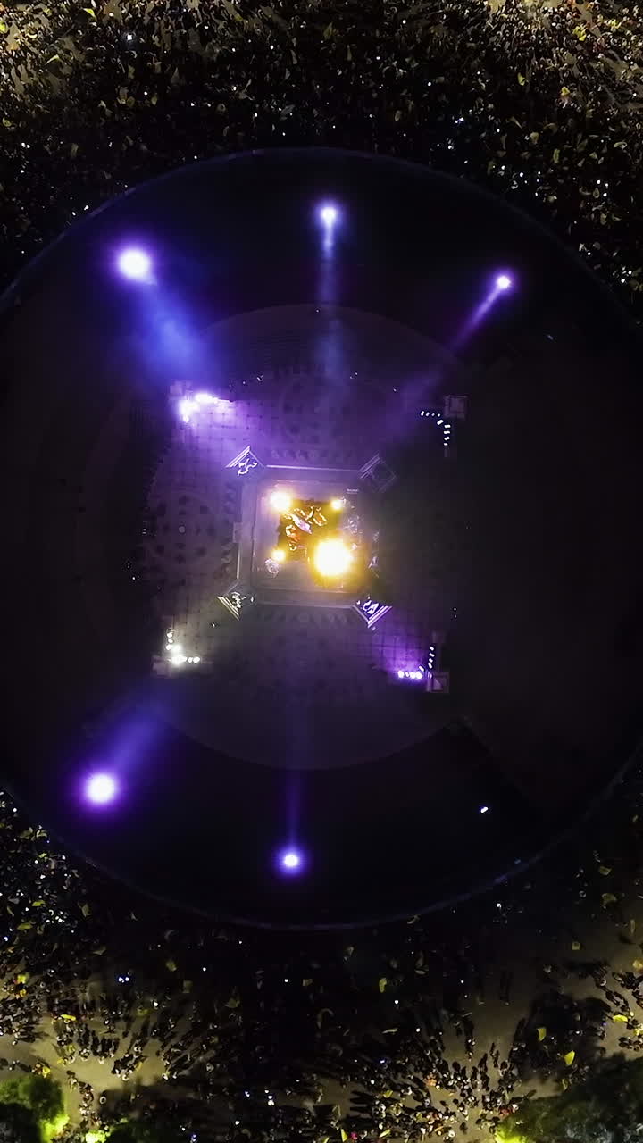 Vertical drone shot above the El Angel statue and crowded streets, night in CMDX