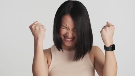 asian woman celebrating victory on camera.