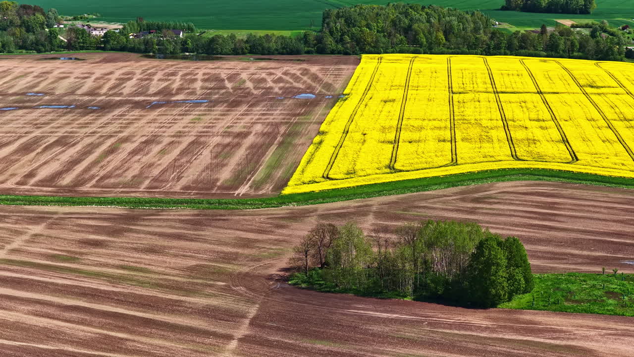 Brown and yellow fields form a vivid agricultural pattern across a rural landscape.