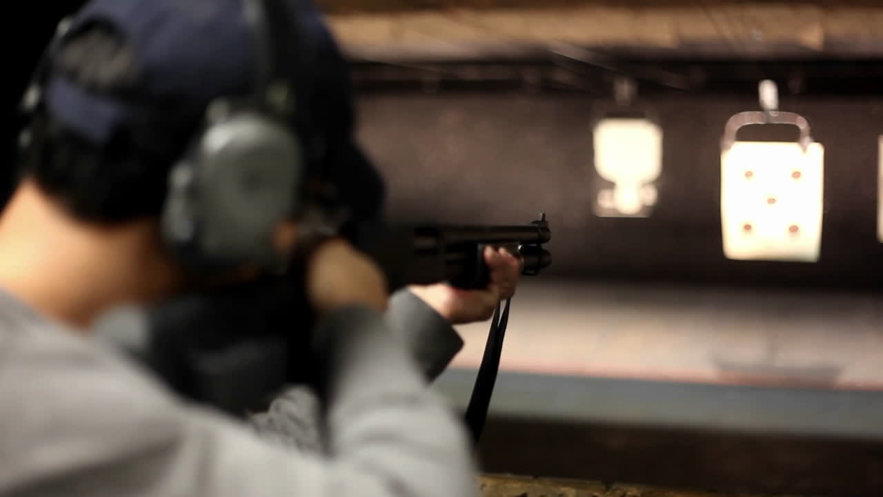 한 남자가 실내 사격장에서 목표물에 소총을 발사합니다.