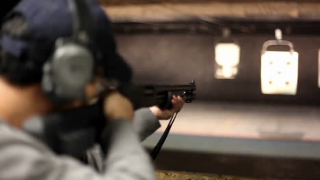 a man fires a rifle at a target at an indoor shooting range