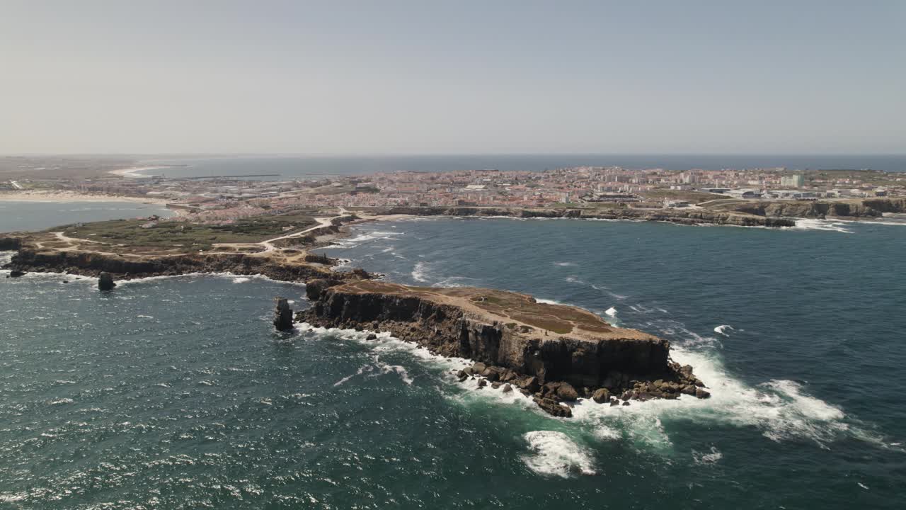 vista aérea en órbita islote rocoso de papoa que revela la península del pueblo de peniche