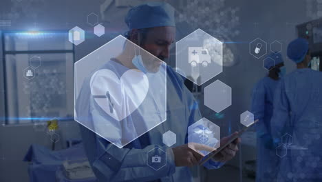 animation of medical icons over caucasian male surgeon using digital tablet at hospital