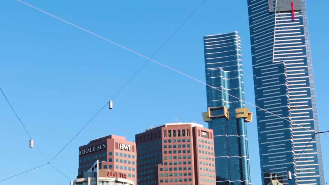 Tall buildings and hanging lights set against a bright blue sky, showcasing urban architecture and design.