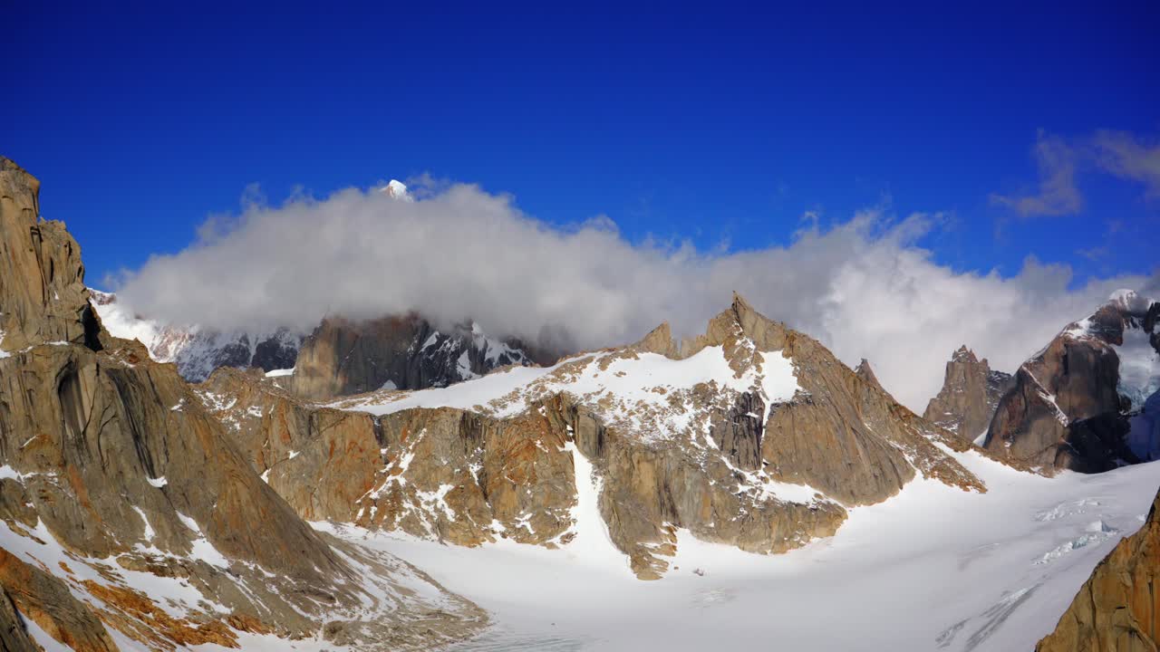Dramatic time-lapse of Cerro Torre with fast-moving clouds surrounding the sharp granite peaks and snowy ridges